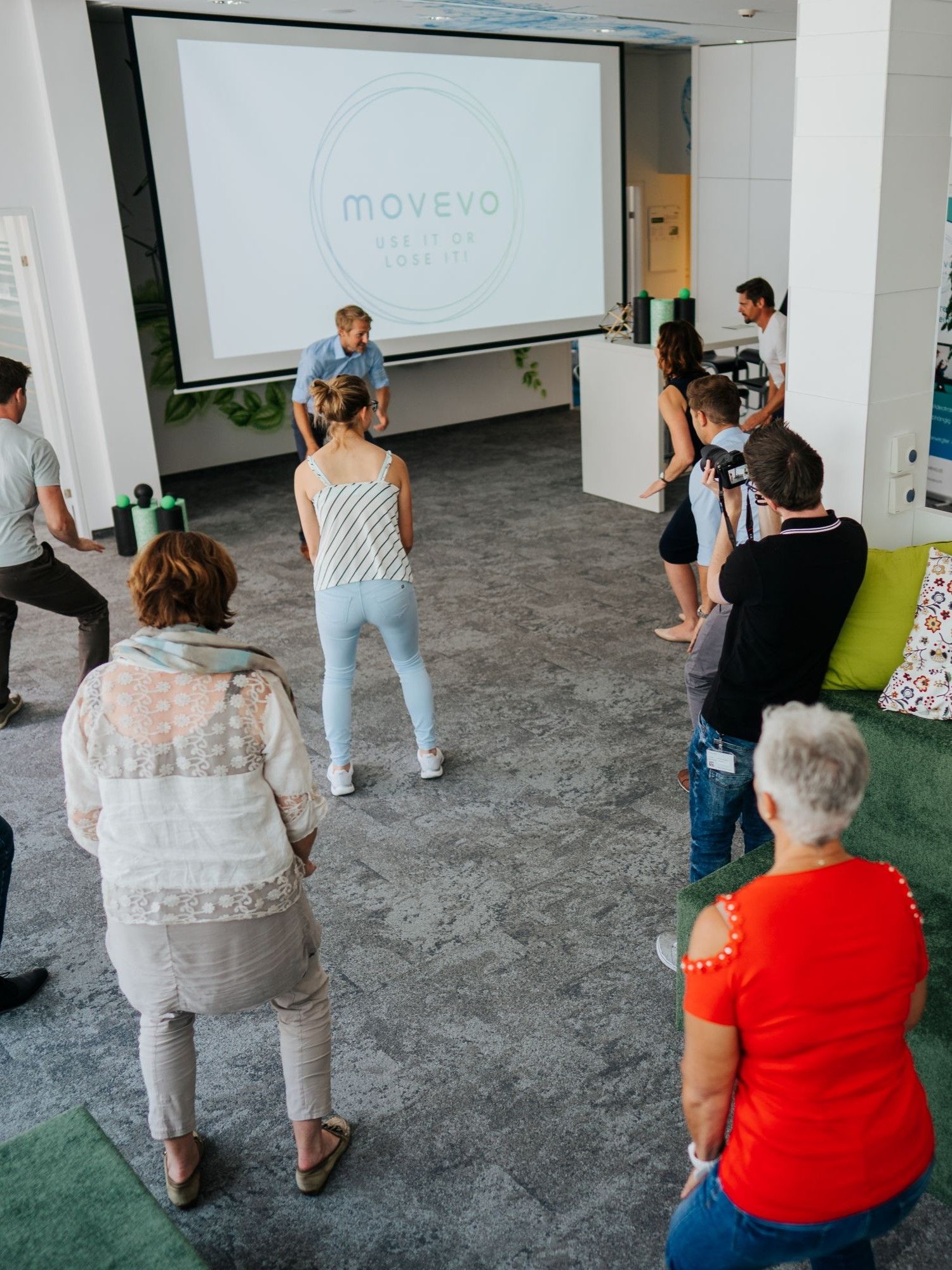 Mehrere MitarbeiterInnen machen gemeinsam eine Übung in den Büroräumlichkeiten